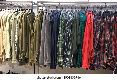 Plaid ,shirts Sorted In Color Order On Hangers On A Shop Wardrobe Closet Rail

