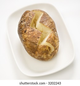 Plain Baked Potato Sliced Down The Middle On A Plate.