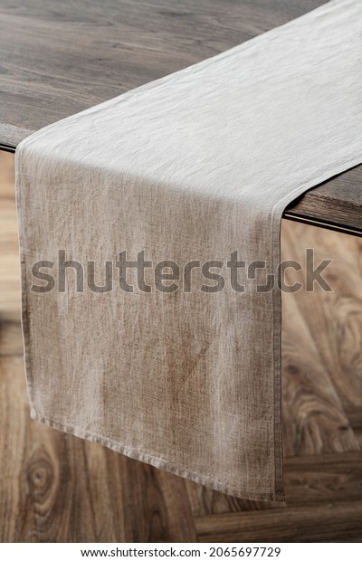 Plain beige table\
runner on a wooden table