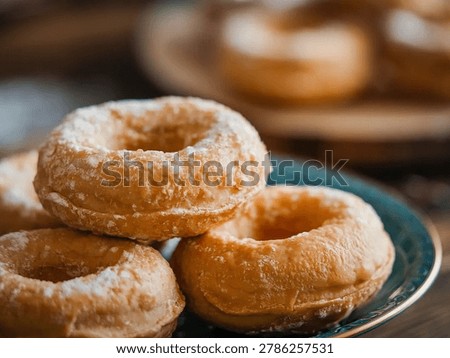 Plain Donuts : Golden lightly sugared ring donuts piled on a blue plate, freshly fried to crisp airy perfection, a classic homestyle bakery treat beloved for breakfast and casual snacking