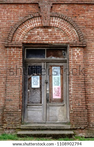 Plain printed signs with the same message stapled to two doors of abandoned old brick building, a hotel long ago, in Point Reyes Station, California: 