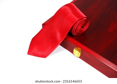 plain red colour neck tie rolled isolated over wooden box with white background noperson 