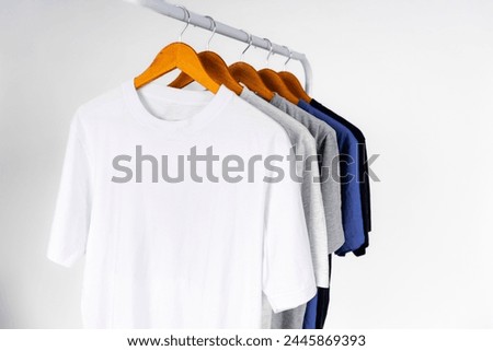 Plain t-shirt, clothes hanging on wooden hanger, front view, isolated on background. Set of fashion apparel