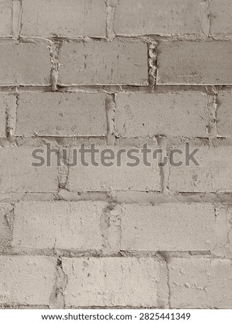 A plain, unpainted cinder block wall with visible mortar lines, presenting a simple, functional, and rugged industrial texture.