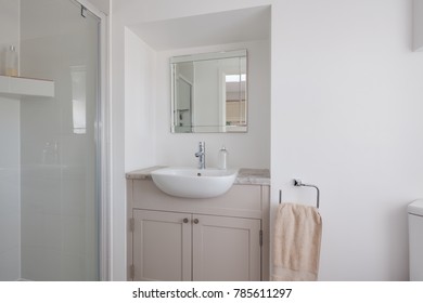 Plain White Decorated White Shower Room Closet With Shower Cubicle, Handbasin Inset Into A Built-in Cuboard, Towel, Mirror W.c. And Soap Dispenser