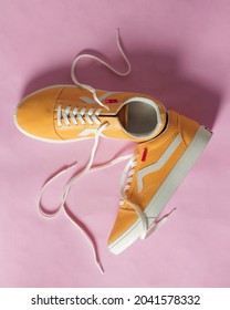 Plain Yellow Converse Sneakers Isolated On A Bright Background Are Very Popular Among Teenagers. A Simple Shoe Model That Is Perfect For School Or For Fashion. Free Space For Your Ad. Shoe Mockup.