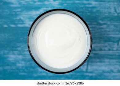 Plain Yogurt In A Bowl On A Blue Decorative Background.