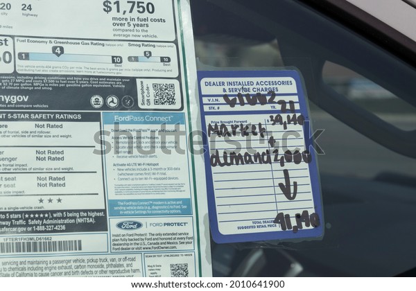 Plainfield - Circa July 2021: Ford Car and SUV\
sticker price with a Market Demand increase in price. Chip\
shortages have allowed dealers to add premium markups to their\
limited inventory.