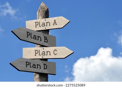 Plan A, plan b, plan c, plan d - wooden signpost with four arrows, sky with clouds
