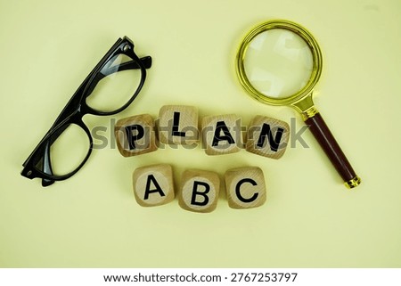 Plan A, Plan B, Plan C with eye glasses and magnifying glass on yellow background