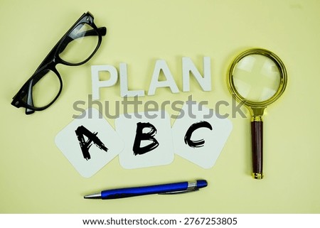 Plan A, Plan B, Plan C with eye glasses and magnifying glass on yellow background
