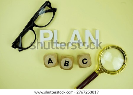 Plan A, Plan B, Plan C with eye glasses and magnifying glass on yellow background