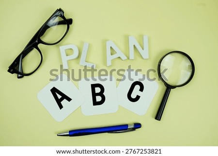 Plan A, Plan B, Plan C with eye glasses and magnifying glass on yellow background