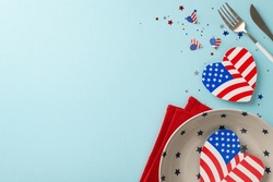 Plan For Independence Day With Inventive Table Arrangement. Top View Of Plate, Silverware, Napkin, Hearts With American Flag Patterns, Confetti On Pastel Blue Background With Space For Text Or Ad