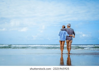 Plan life insurance of happy retirement concepts. Senior couple walking on the beach holding hands at beach sunrise in evening. - Powered by Shutterstock