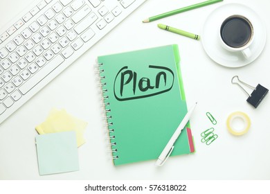  plan text on notepad with keyboard and stationary on table