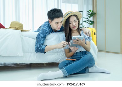 Plan vacation trip holiday. Loving couple searching information on tablet and booking hotel. Couple Booking Hotel Using Tablet Computer Sitting At room.