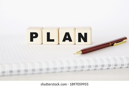PLAN written word. cubes, notepad and pen.. You can use in business, marketing and other concepts. Messege of the day.