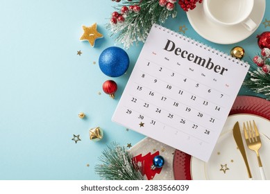 Plan your restaurant reservation for special event. Top view of December calendar, plates, elegant cutlery, coffee mug, glistening baubles, candle, frosty fir twigs, mistletoe on soft blue backdrop - Powered by Shutterstock