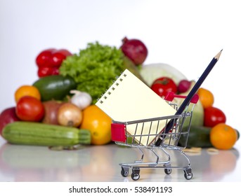 Plan Your Shopping List In A Food Shop - Trolley With A Notebook In The Foreground. Saving Concept