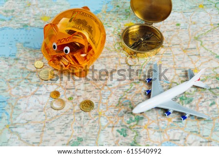 Plan your trip, calculate your traveling budget. Piggy bank with currency, compass, plane, Coins and map. Top view composition