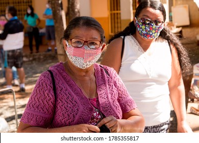 Planaltina, Goias, Brazil-July 25 2020: Two Women Wearing A Protective Mask While Waiting For Food At A Distribution Center For The Poor Of The Community