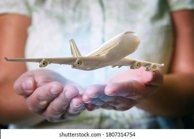 A Plane Airliner Over Woman's Hands In A Protective Position. Aircraft Industry Concepts, Airline Safety And Insurance 