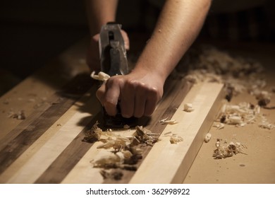 Plane being worked by male hands on strips of wood. - Shutterstock ID 362998922