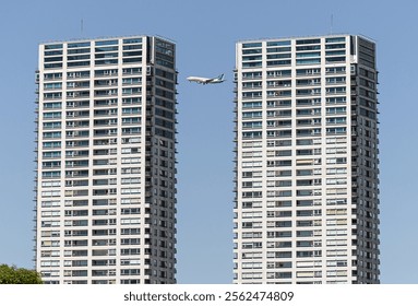 A plane is currently flying securely between two tall, impressive buildings in a bustling metropolitan area filled with skyscrapers