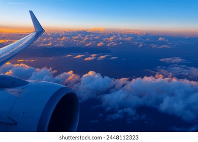 Plane engine and wing gracefully soar over clouds during the evening. Flying over Canary Islands in Atlantic Ocean 