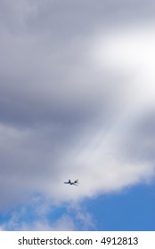 plane flying between clouds on a sunny day