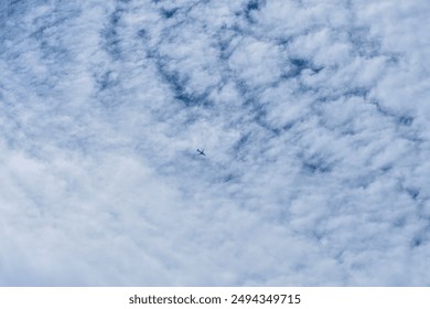Plane flying in the clouds in summer