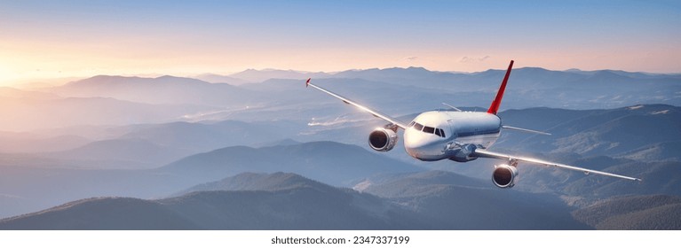 Plane is flying in colorful sky at sunset. Landscape with passenger airplane over mountains ranges and hills in fog, orange sky. Aircraft is landing. Business. Aerial view. Transport. Private Jet - Powered by Shutterstock