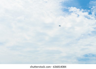 The plane is flying through clouds in the sky at morning.