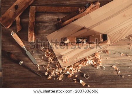 Plane jointer carpenter or joiner tool and wood shavings. Woodworking tools on wooden table. Carpentry workshop