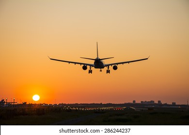 Plane Landing During A Nice Sunrise.