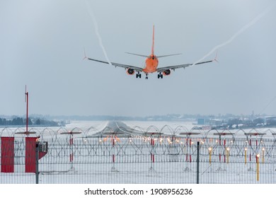 The plane with landing lights on and released chassis prepare for landing. Rear view