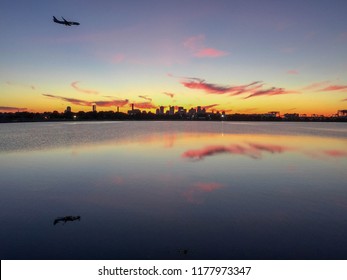 Plane Landing At Logan Airport During Sunset