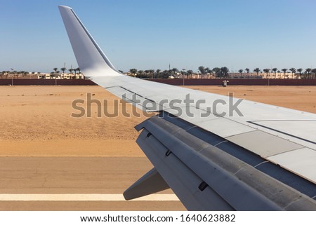 The plane lands on the airfield. Spoilers and flaps trailing edge when landing. View of the earth from the wing of the aircraft. Sinai. Egypt.
