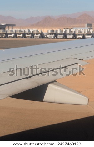 The plane lands on the airfield. Spoilers and flaps trailing edge when landing. View of the earth from the wing of the aircraft. Sinai. Sharm El Sheikh, Egypt.