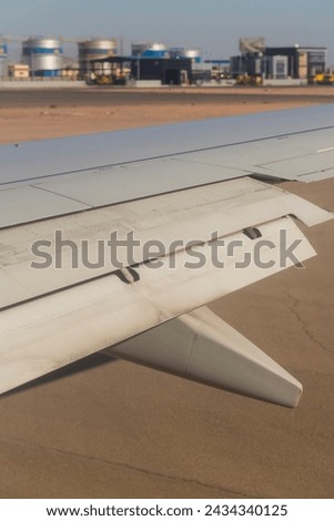 The plane lands on the airfield. Spoilers and flaps trailing edge when landing. View of the earth from the wing of the aircraft. Sinai. Sharm El Sheikh, Egypt.