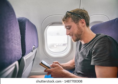 Plane Passenger Man Texting On Mobile Phone Using In-flight Onboard Wifi Internet On Business Travel Trip Holding Cellphone. 5G Technology Device.