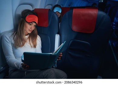 Plane Passenger In Sleep Mask Reading A Book