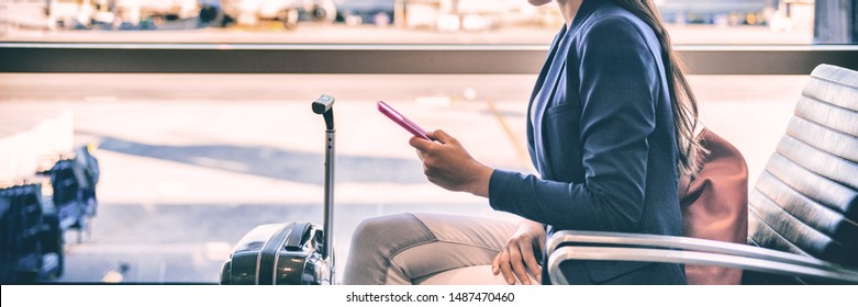 Plane passenger woman waiting for flight departure texting sms message on mobile phone at lounge airport. Businesspeople travel lifestyle panoramic banner. - Powered by Shutterstock