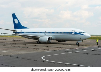 The Plane Is Standing On The Runway. Maintenance Of The Aircraft After An Emergency Landing. A Mechanic Stands Next To The Airliner And Prepares It For Takeoff.