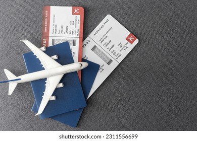 Plane tickets, passports and toy plane on table