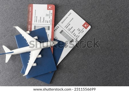 Plane tickets, passports and toy plane on table