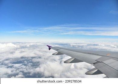 Plane Window With Blue Sky And Clouds Outside