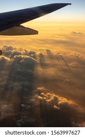 plane wing with cloud lit by oblique sun rays horizon and sky