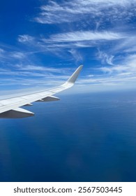 Plane wing outside window over water. 